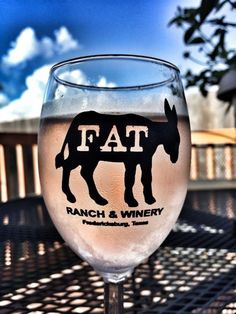 a glass filled with wine sitting on top of a table