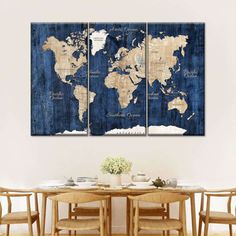 a dining room table with chairs and a large world map on the wall above it