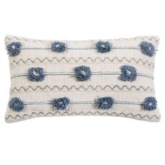 a white and blue pillow with pom poms