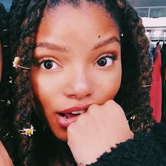 a close up of a person with curly hair and an open hand near her face