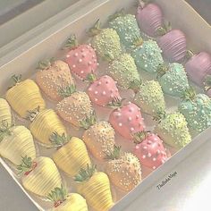 a box filled with lots of different colored strawberries