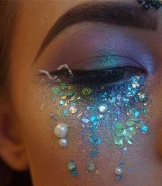 a woman's face with glitter on her eyes and eyeliners in the shape of stars