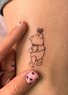 a woman's stomach with a small tattoo of a pooh bear