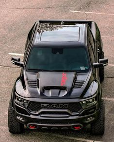 the front end of a black truck parked in a parking lot