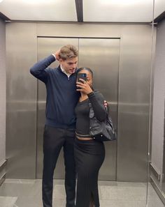 a man and woman taking a selfie in an elevator