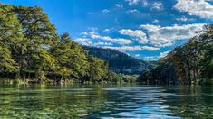 the water is crystal green and clear with trees on both sides in the foreground