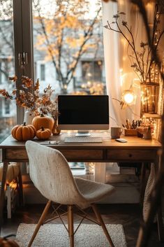 a desk with a computer on it in front of a window filled with pumpkins