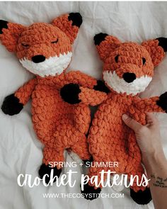 two crocheted stuffed animals laying next to each other on top of a bed