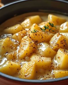 a bowl filled with potatoes and gravy on top of a table