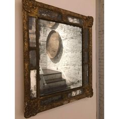 an old mirror is hanging on the wall in front of a brick wall with books