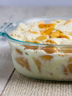 a casserole dish with oranges and cream in it on a wooden table