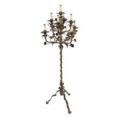 a tall metal candle holder with five candles on it's base and four arms