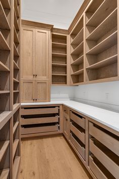 an empty kitchen with wooden cabinets and white counter tops