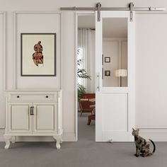 a cat sitting on the floor in front of an open door to a living room