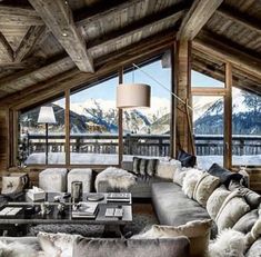 a living room filled with lots of furniture next to a large window covered in snow