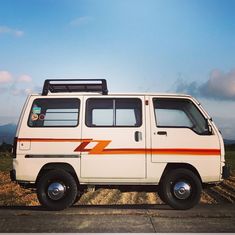 a white van is parked on the side of the road in front of a field