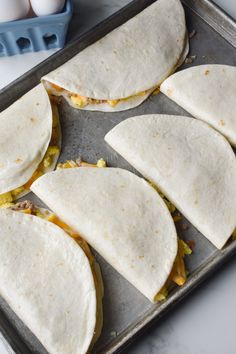 six tortillas sitting on top of a baking sheet