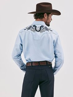 MADE FOR THE TAILORED COWBOY Class up any outfit you're wearing with the Wrangler® Rodeo Ben Western Snap Shirt. Inspired by our early years, this eye-catching take on the cowboy classic is meticulously made down to the smallest detail. It comes with a vintage-inspired pattern, fancy yokes, detailed embroidery, and pearl snaps for a polished look. Dressier than most, this embellished snap shirt for men is crafted from 100% cotton for long-lasting comfort and quality. Western Style Relaxed Fit Shirt For Ranch, Western Style Relaxed Fit Shirt For Spring, Blue Shirt For Rodeo In Spring, Blue Shirt For Spring Rodeo, Western Style Blue Tops For Spring, Western Blue Button-up Top, Blue Button-up Shirt For Ranch, Western Cotton Shirt For Country Events, Western Style Blue Relaxed Fit Tops