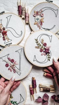 the woman is working on her embroidery project with scissors and needle tips in front of them