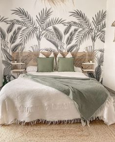 a bedroom with palm trees painted on the wall and bed in between two nightstands