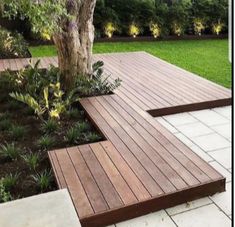 a wooden bench sitting next to a tree on top of a white tile flooring