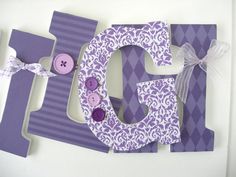 the letter g is made out of purple paper and decorated with buttons, ribbons and bows