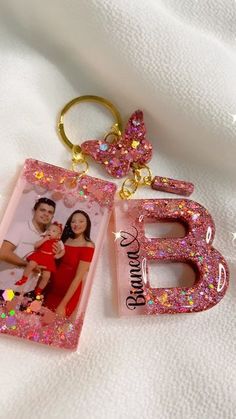 a keychain with an image of a man and woman in pink glitter on it