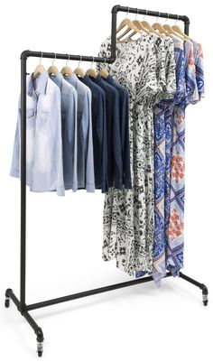 an ironing rack with clothes hanging from it's sides and four shirts on hangers