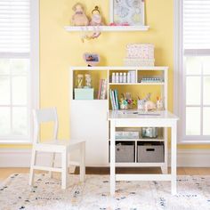 a child's desk and chair in a room with yellow walls, white furniture and windows