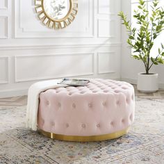 a pink ottoman sitting on top of a rug