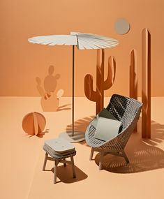 an image of a desert setting with chairs and umbrellas in the foreground, cactus silhouettes in the background