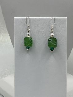 Green glass bead earrings. Finished with silver findings. Green Beaded Earrings With Silver Beads As Gift, Handmade Silver Beaded Glass Earrings, Silver Glass Bead Round Earrings, Silver Dangling Beads Glass Earrings, Silver Beaded Earrings With Round Glass Beads, Silver Glass Earrings With Dangling Beads, Adjustable Silver Glass Beaded Earrings, Silver Earrings With Dangling Glass Beads, Green Sterling Silver Beaded Earrings With Round Beads