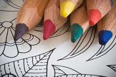 several colored pencils sitting on top of a coloring page with flowers and leaves in the background