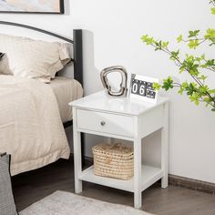 a bedroom with a bed, nightstand and pictures on the side table next to it