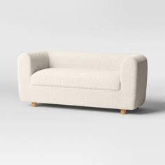 a white couch sitting on top of a gray floor