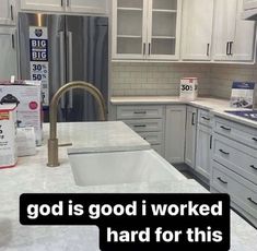 a kitchen with white cabinets and marble counter tops that says god is good i worked hard for this