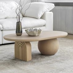 a white couch sitting next to a table on top of a carpeted living room floor