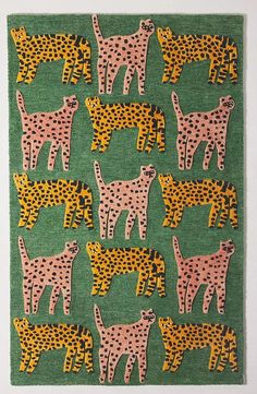 a green rug with pink and yellow cheetah on the front, and black dots on the back