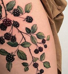 a woman's thigh with berries and leaves on it