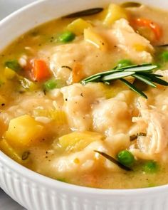 a white bowl filled with chicken and vegetable soup