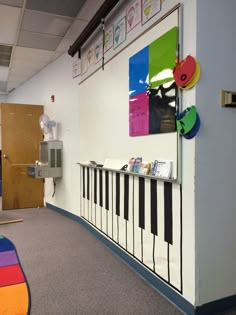 a room with a piano on the wall and colorful decorations hanging from it's sides