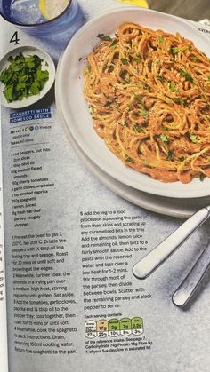 an article in the food and drink magazine features spaghetti with sauce, lemon wedges and parsley