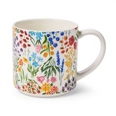 a coffee mug with colorful flowers painted on it's side and inside the cup