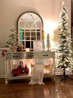 a living room decorated for christmas with white trees and decorations on the table in front of it