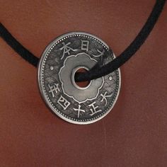 JAPANESE COIN charm necklace -circulated antique japanese coin from over 70 years ago -polished and clean coin -I have numerous of these coins in similar condition with slight variation in patina -you will receive a 24 inch adjustable black cord necklace ADD A CHAIN https://www.etsy.com/listing/96277094/chain-necklace-copper-brass-stainless?ref=v1_other_1 MORE COINS HERE http://www.etsy.com/shop/PartsForYou?section_id=7867468 MY OTHER SUPPLIES AND EARRING SHOP AT http://www.etsy.com/shop/CecileS Good Luck Coin-shaped Amulet Jewelry, Good Luck Coin Amulet Jewelry, Good Luck Coin Shaped Amulet Jewelry, Antique Medallion Jewelry For Good Luck, Vintage Coin Pendant Jewelry For Good Luck, Vintage Good Luck Coin Pendant Jewelry, Traditional Coin Shaped Good Luck Jewelry, Traditional Round Disc Jewelry As Gift, Adjustable Engraved Coin Jewelry