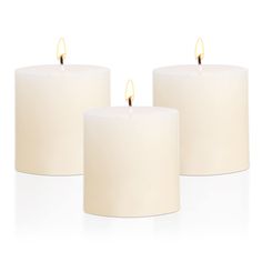 three white candles sitting next to each other