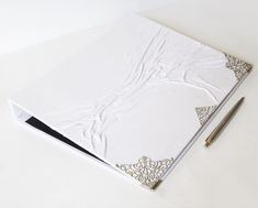 a notebook with a pen on top of it next to an empty notepad and pencil