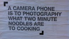 there is a sign on the wall that says a camera phone is to photography what two minute noodles are to cooking