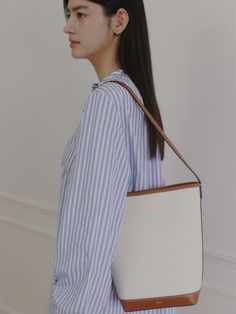 Editor's NoteROWH presents a timeless design that complements a variety of outfits.- Minimal bucket type bag- One handle, medium-sized shopper bag- Classic and spacious design- Inner open pocket detailMeasurements(in.)- Size: 10.24 in. * 10.83 in. * 4.72 in.- Strap: 10.24 in. Composition & Care- Upper: 100% Cotton, 100% Cow Leather / Lining: 65% Polyester, 35% Cotton / Strap: Cow Leather- Natural leather may have fine scratches and wrinkles- Bright leather can get stained by denim or da Classic Office Tote Bucket Bag, Rectangular Beige Bucket Bag For Work, Rectangular Beige Hobo Bag For Work, Versatile Leather Handles Bucket Bag For Office, Versatile Style Bucket Bag With Leather Handles, Beige Bucket Bag With Leather Handles For Work, Leather Handle Bucket Box Bag For Shopping, Beige Hobo Bag For Work, Versatile Office Bucket Bag With Leather Handles