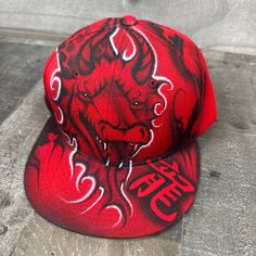 This is an airbrushed snapback hat featuring a Red Dragon design.  The Calligraphy on the hat reads "dragon". This hat is adjustable and will fit almost anyone.  These hats are waterproof and can withstand a good soaking but they should not be washed in a washing machine or dish washer.  Thank you, Brad.  Shipping is free for this item anywhere in the US. Red Flat Brim Fitted Hat For Streetwear, Red Hip Hop Fitted Hat With Flat Bill, Red Hip Hop Snapback Hat, Red Hip Hop Fitted Hat For Streetwear, Red Fitted Cap For Streetwear, Red Fitted Hat With Flat Crown For Streetwear, Red Hip Hop Snapback Hat For Streetwear, Red Fitted Hat With Curved Brim For Streetwear, Red Fitted Hat For Streetwear